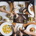 des personnes autours de table et plats